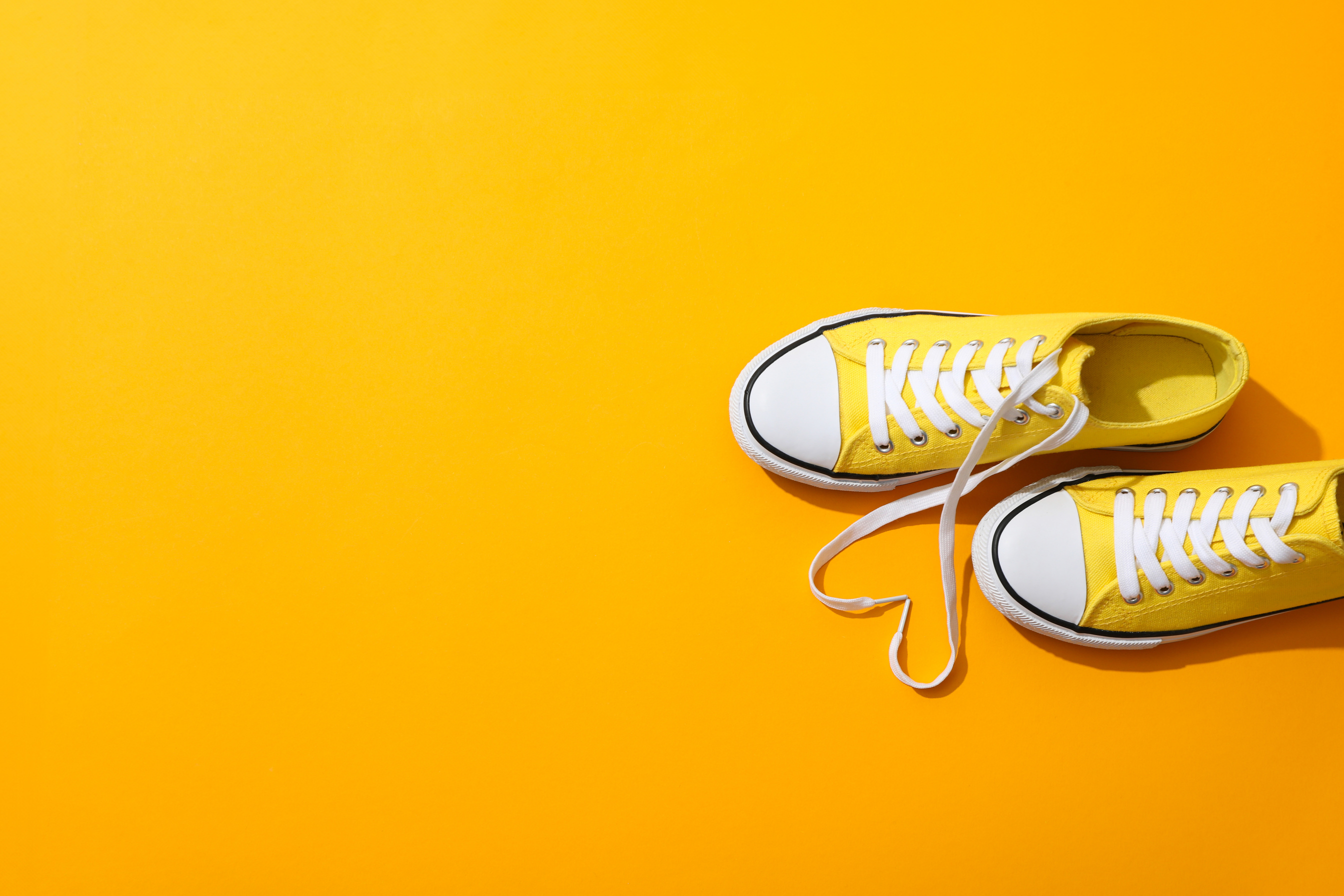 Yellow sneakers with flowers on a yellow background
